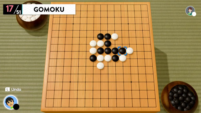 A gomoku board with white and black tokens placed on it