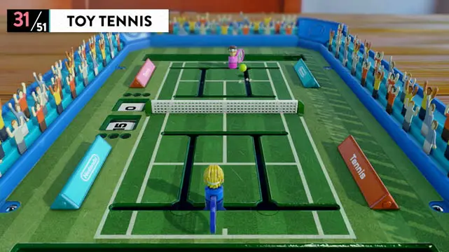 Two toy players on a miniature tennis court playing tennis