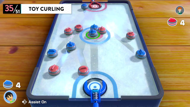 Multiple toy curling pucks on a miniature curling court