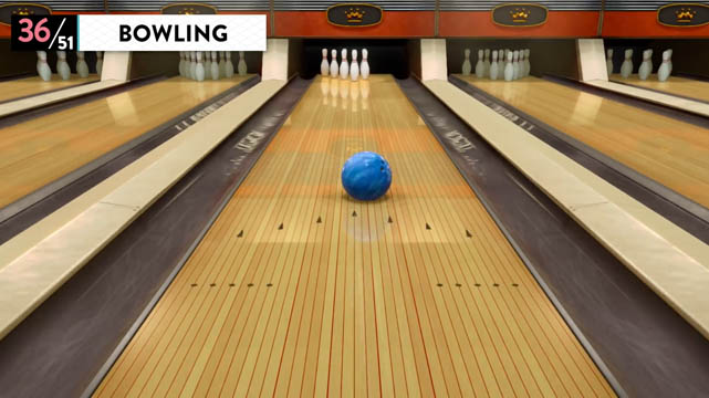 A bowling ball being tossed down a lane towards pins