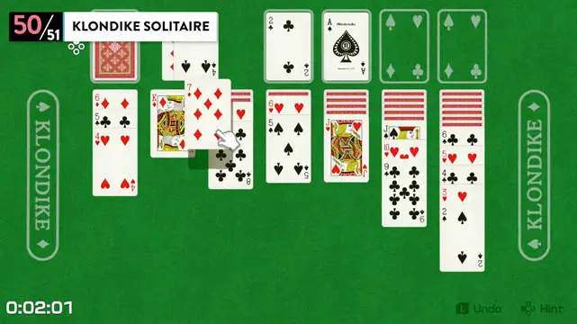 Solitaire playing cards placed on top of a green tabletop