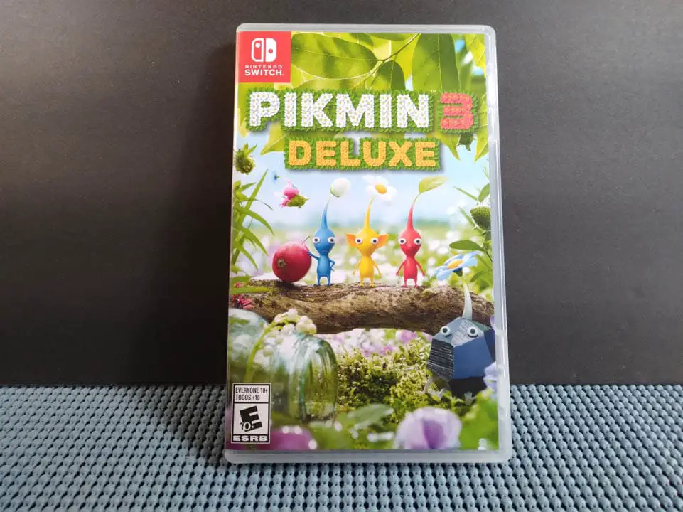 Pikmin 3 Deluxe case resting against a black background and blue matt