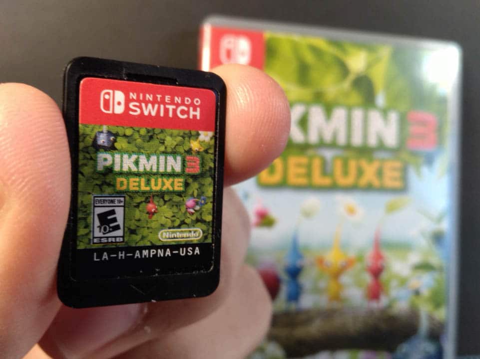 Pikmin 3 Deluxe game card in front of the game's game case
