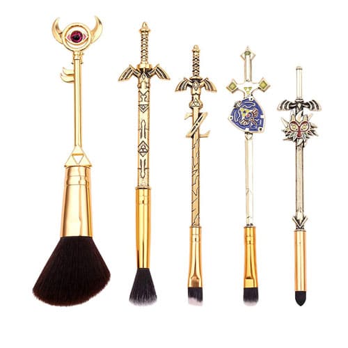 Five makeup brushes, golden and designed to mimic the look of weapons and keys from the Zelda series