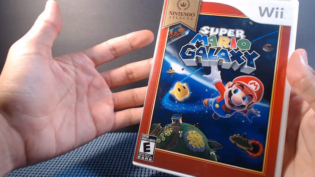 a pair of hands motioning to a video game case