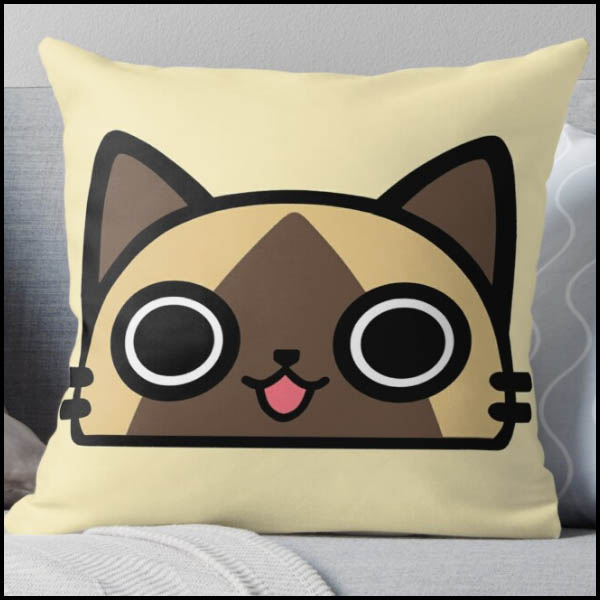 A pillow with a cartoon cat face on front