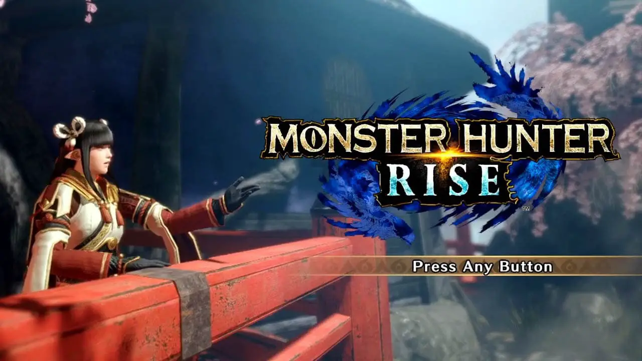 A woman next to a red wooden fence, motioning to the Monster Hunter Rise logo (title screen)