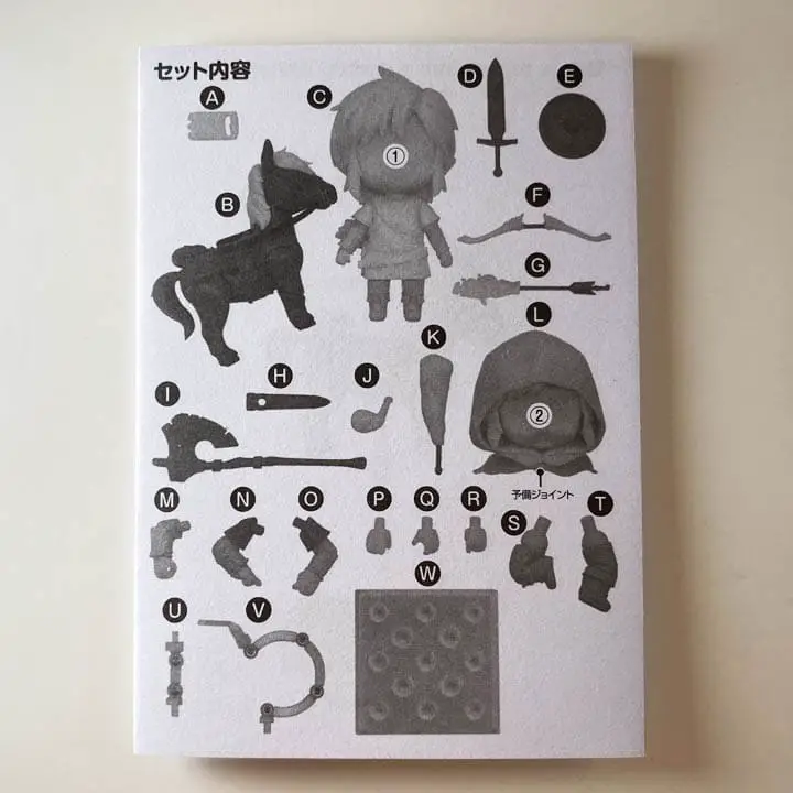 A black and white instruction booklet on a white table top (link nendoroid unboxing)