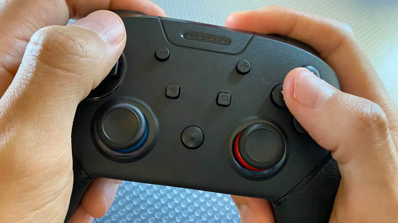 hands holding a nintnendo switch controller
