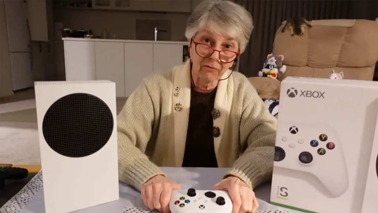 a woman sitting at a table with the xbox series s on the tabletop