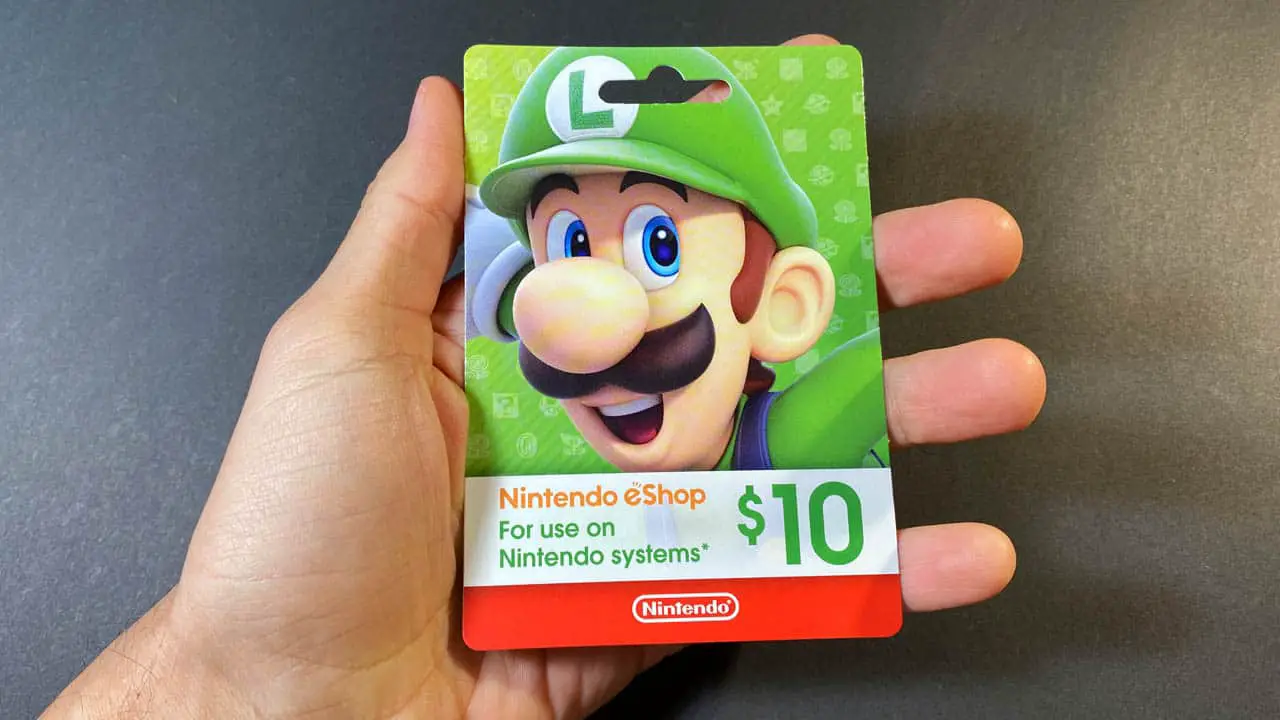 hand holding a green nintendo gift card